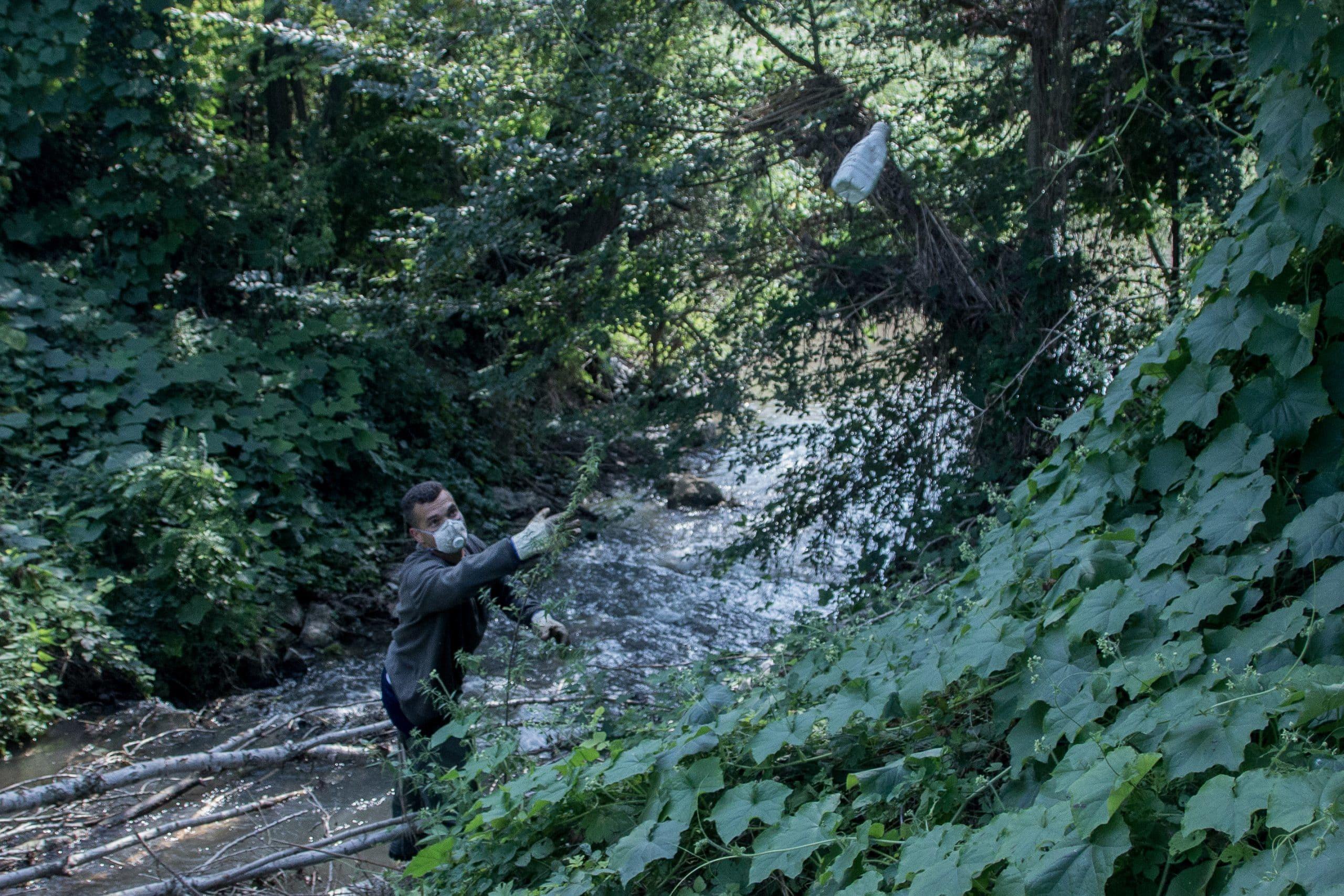 Simone, un membro degli “Angeli del Chiese” durante una giornata di pulizia. L’acqua di questo canale che sfocia nel Chiese è talmente sporca che per immergersi ha dovuto indossare guanti e maschera.