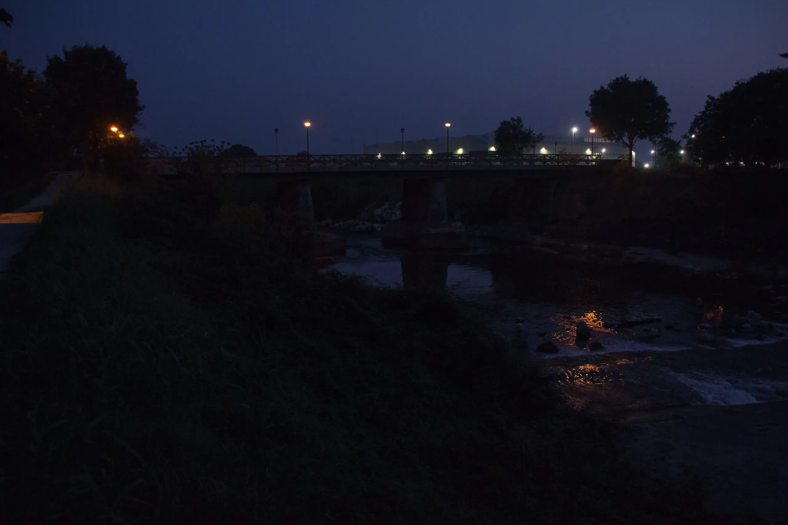 Ponte di Montichiari, sullo sfondo la Cartiera di Montichiari che utilizza le acque del Chiese per la lavorazione. Spesso è stata accusata di aver inquinato il fiume.